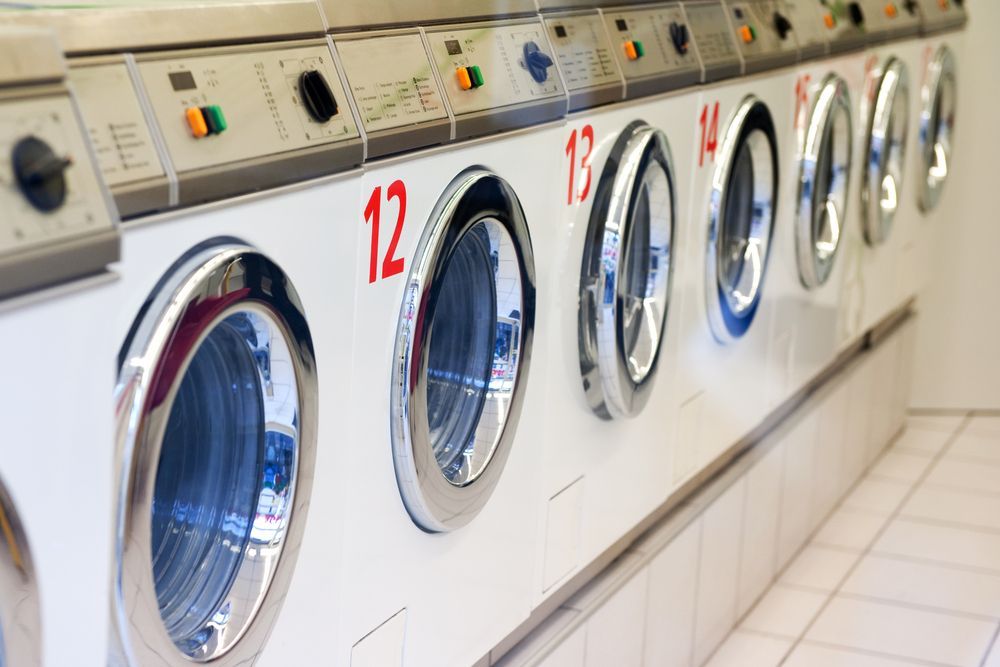 Row of White Industrial Laundry Dryers — Flynns Beach Service Laundry in Thrumster, NSW