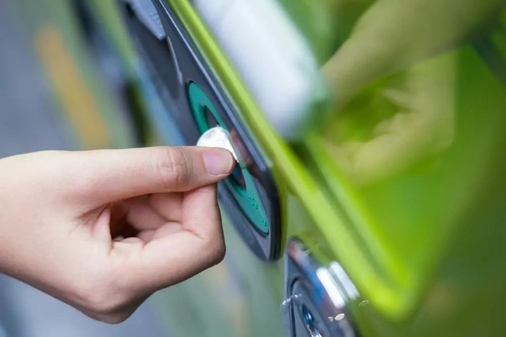 Close-up of a Hand Inserting a Silver Coin — Flynns Beach Service Laundry in Port Macquarie, NSW