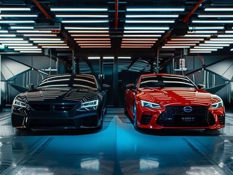 Two cars, one black, one red, parked in a modern, well-lit garage.