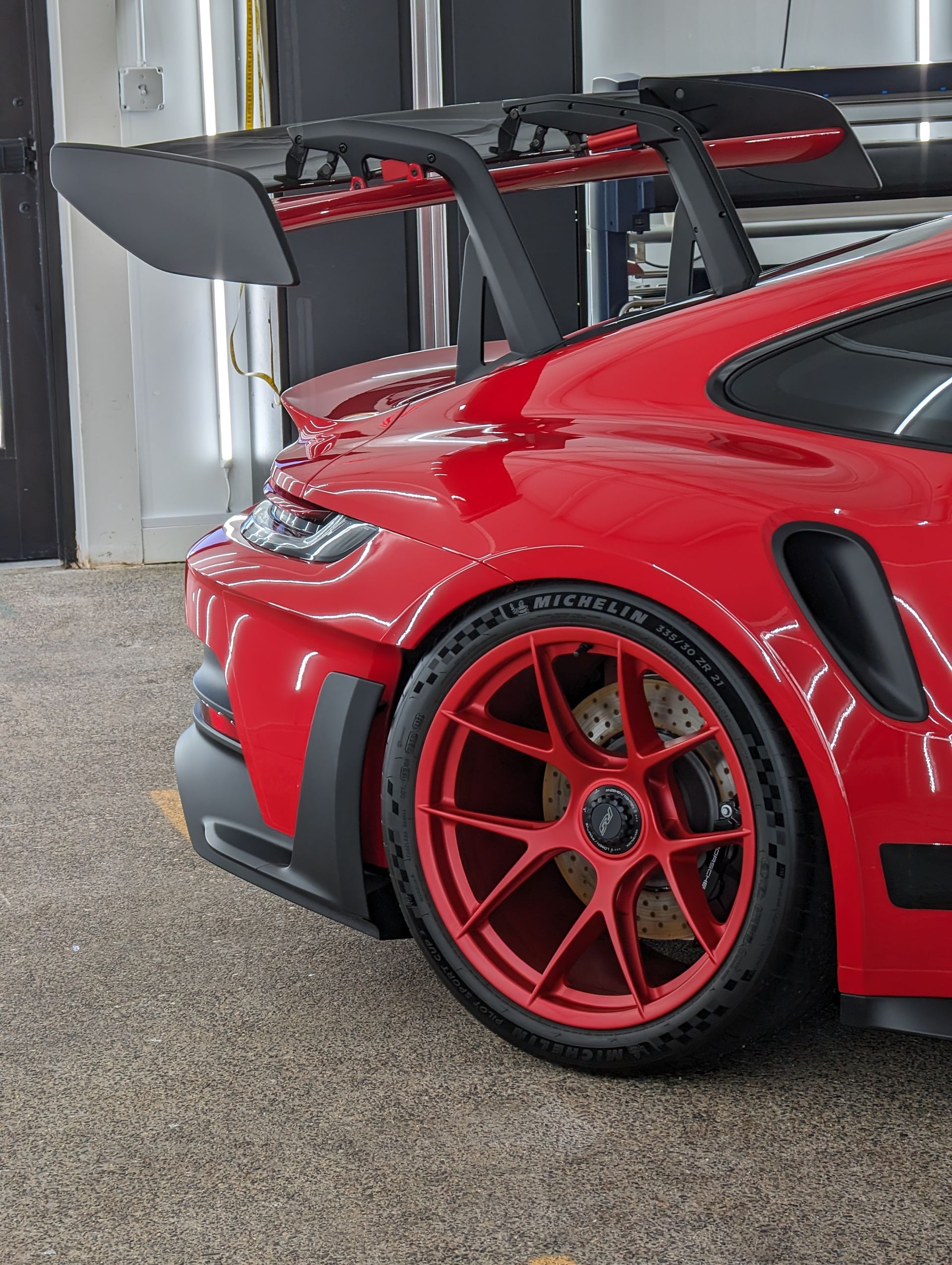 Red Porsche sports car with a large spoiler and red wheels.