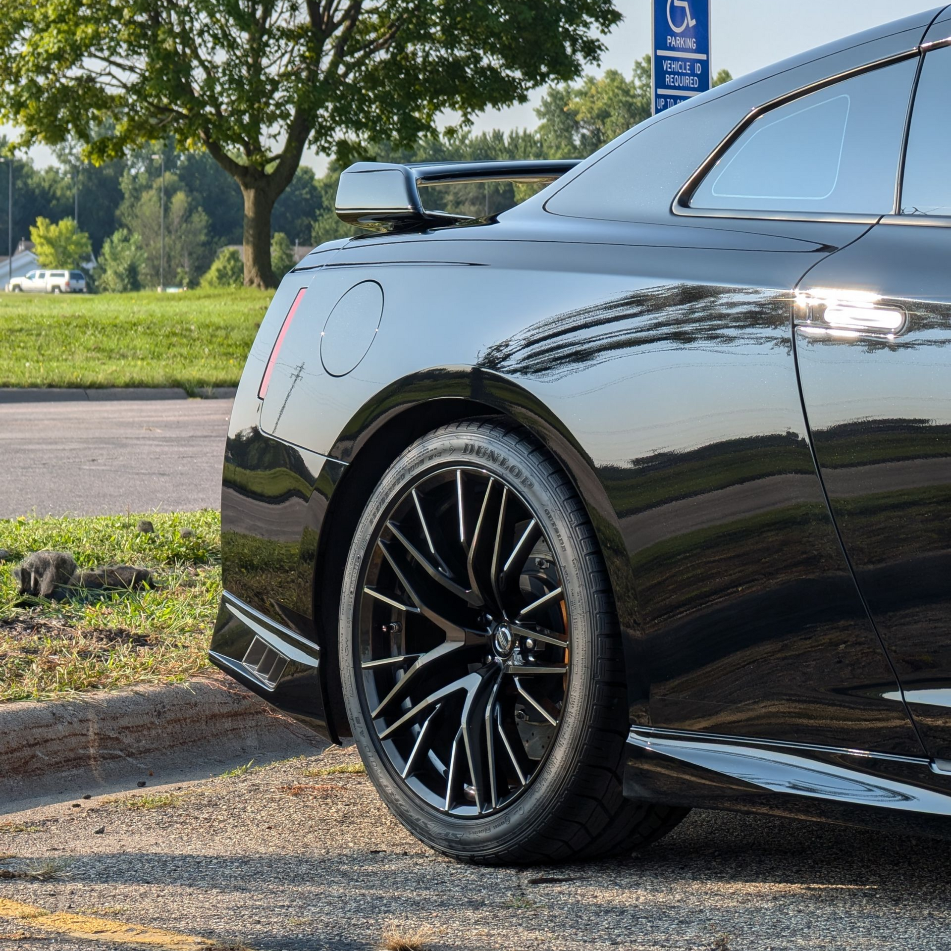 Interior view of a Mazda car dashboard, steering wheel, and console; black with silver accents.