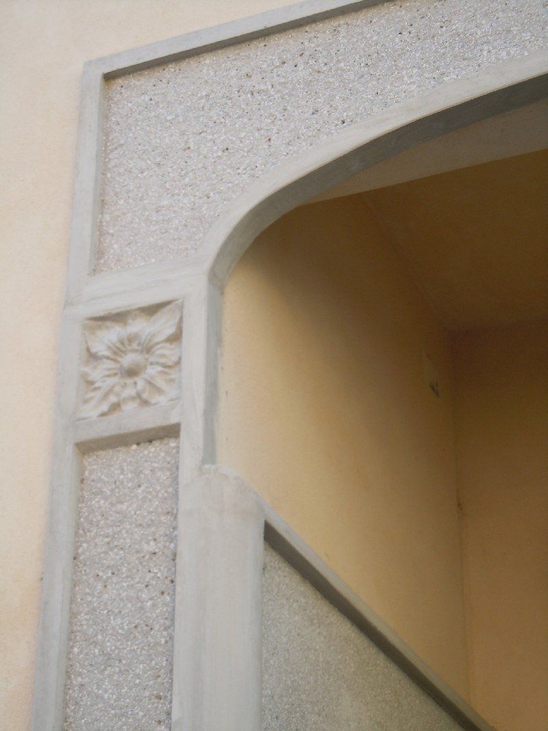 Particolare di portale in cemento con finizione in graniglia martellinata zona Tortona