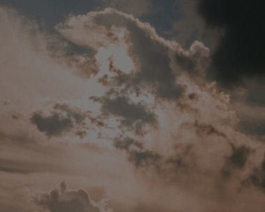 Overcast sky, dark grey clouds with patches of sunlight breaking through.