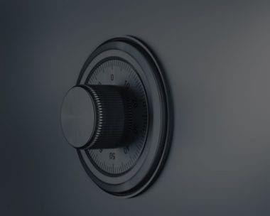 Close-up of a safe dial, black metal with a circular numbered dial.