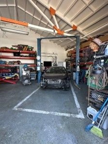 Car on A Lift in A Garage — Santa Cruz, CA — Santa Cruz All Star Body Works
