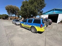 Blue and Yellow SUV Is Parked in Front of A Garage — Santa Cruz, CA — Santa Cruz All Star Body Works