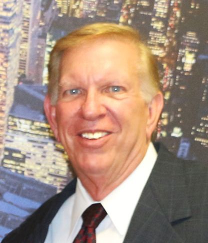 A man in a suit and tie smiles for the camera