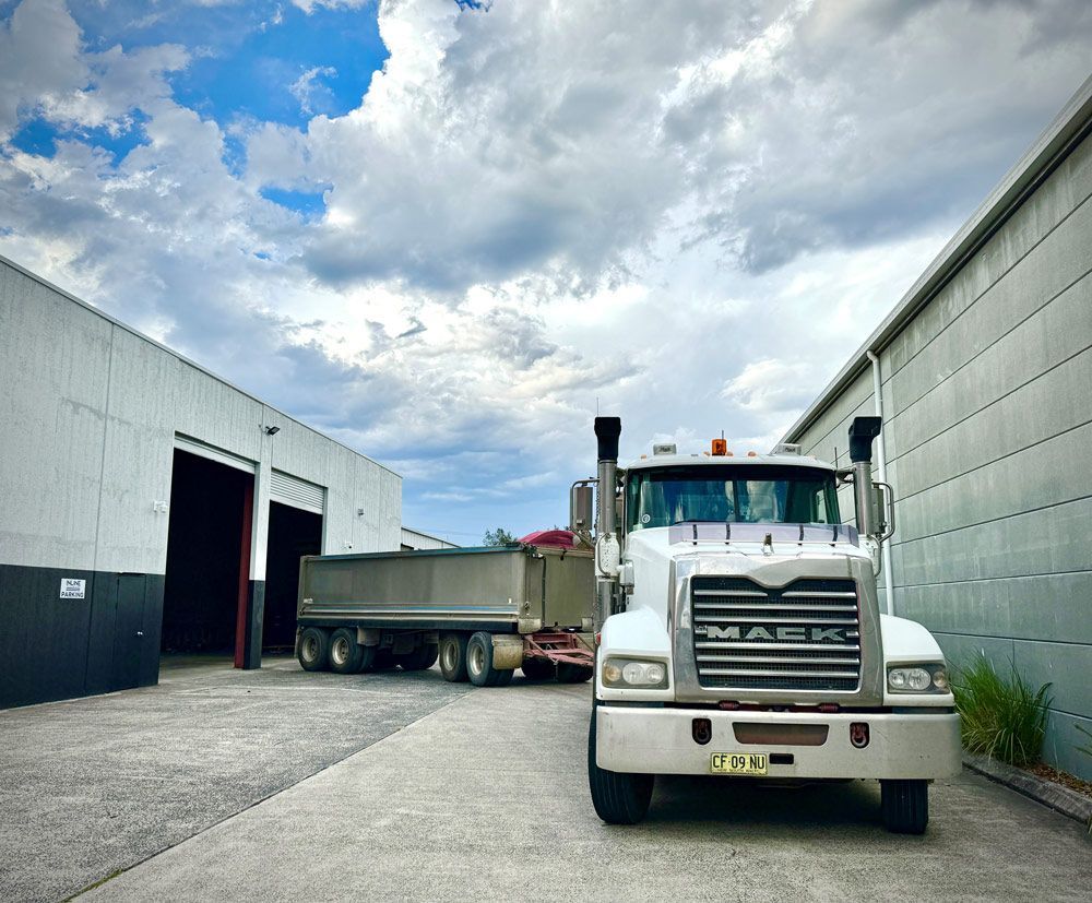 A Dump Truck is Parked in Front of a Building — Inline Truck and Plant in Tuggerah, NSW