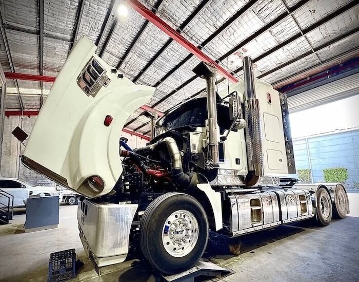 A semi truck with its hood up is sitting in a garage — Inline Truck and Plant in Tuggerah, NSW