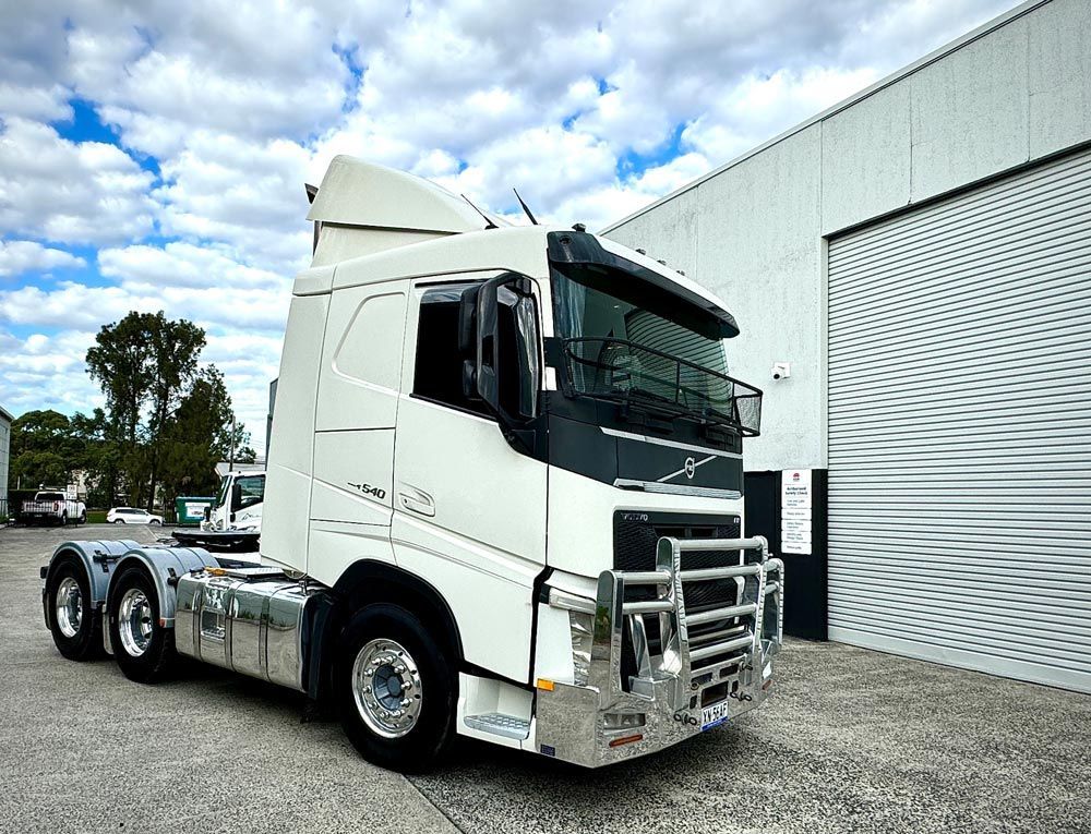A White Semi Truck Is Parked in Front of A Building — Inline Truck and Plant in Tuggerah, NSW