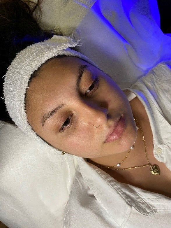 a woman is laying on a bed with a towel on her head.