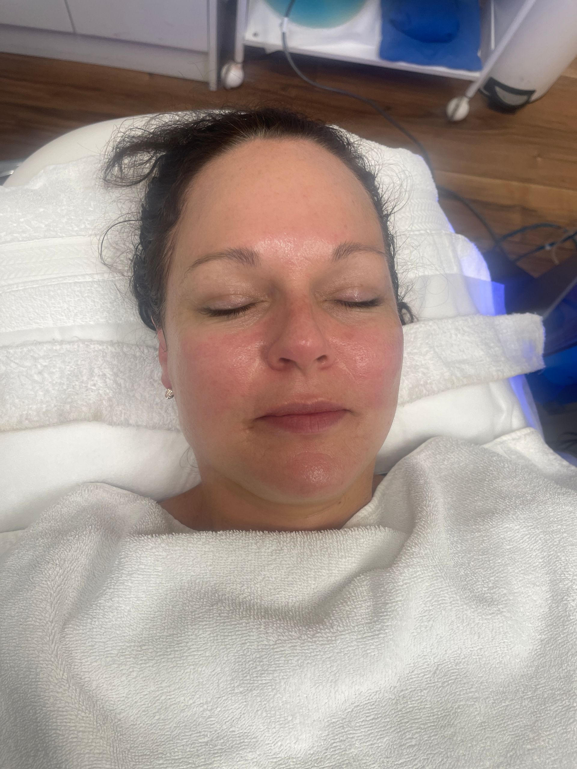 a woman wrapped in a white towel with her eyes closed