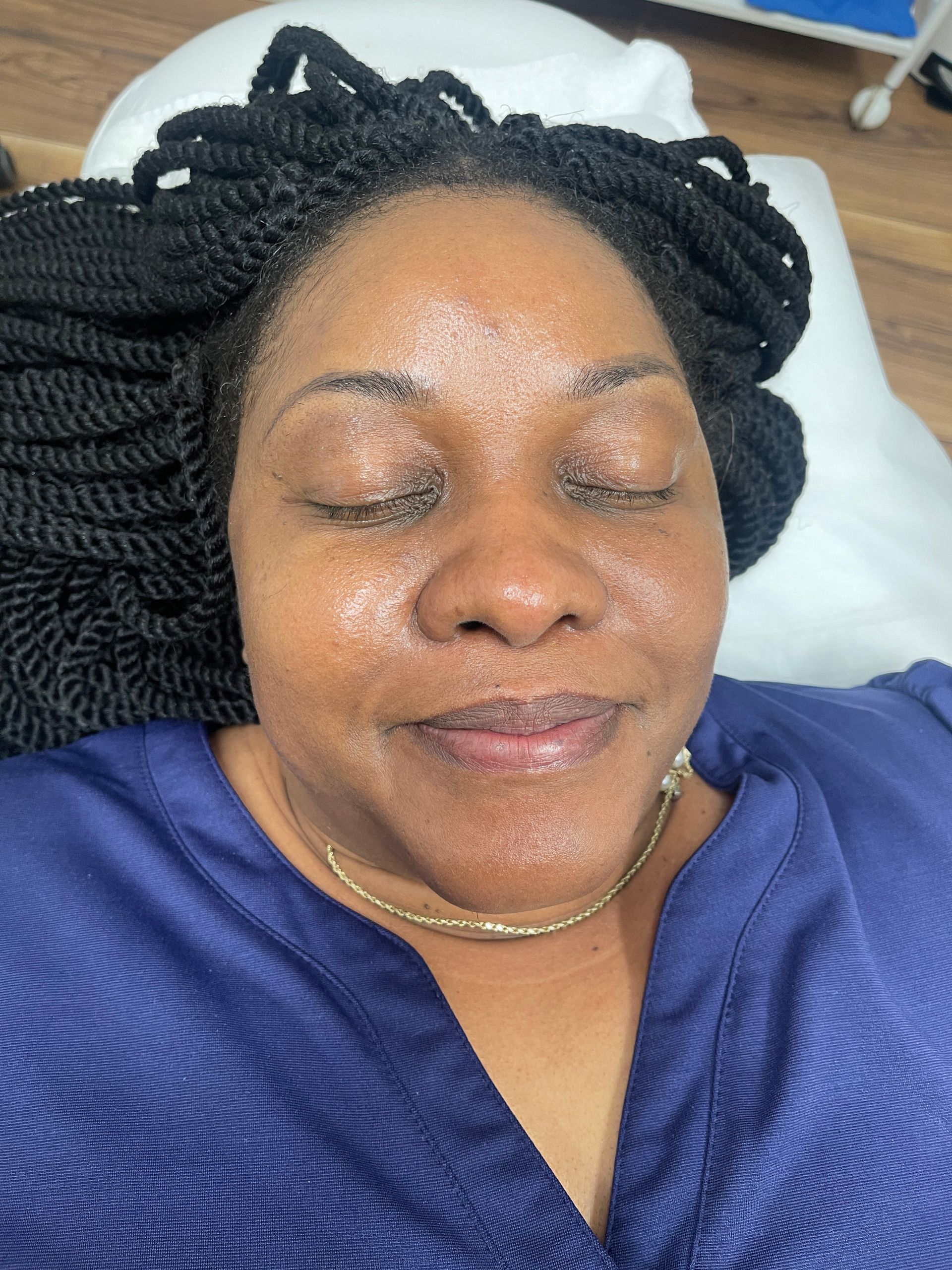 a woman with braids is smiling with her eyes closed