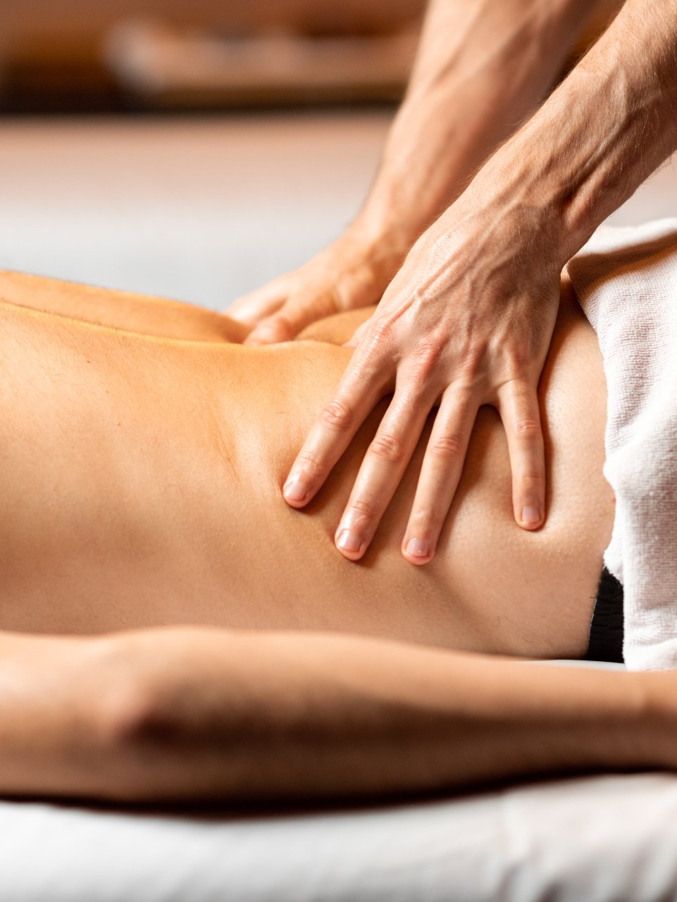 A woman is getting a massage from a man in a spa.