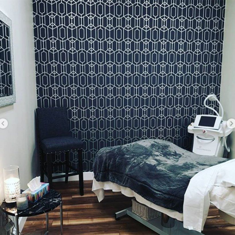 A room with a bed , chair , table and mirror.