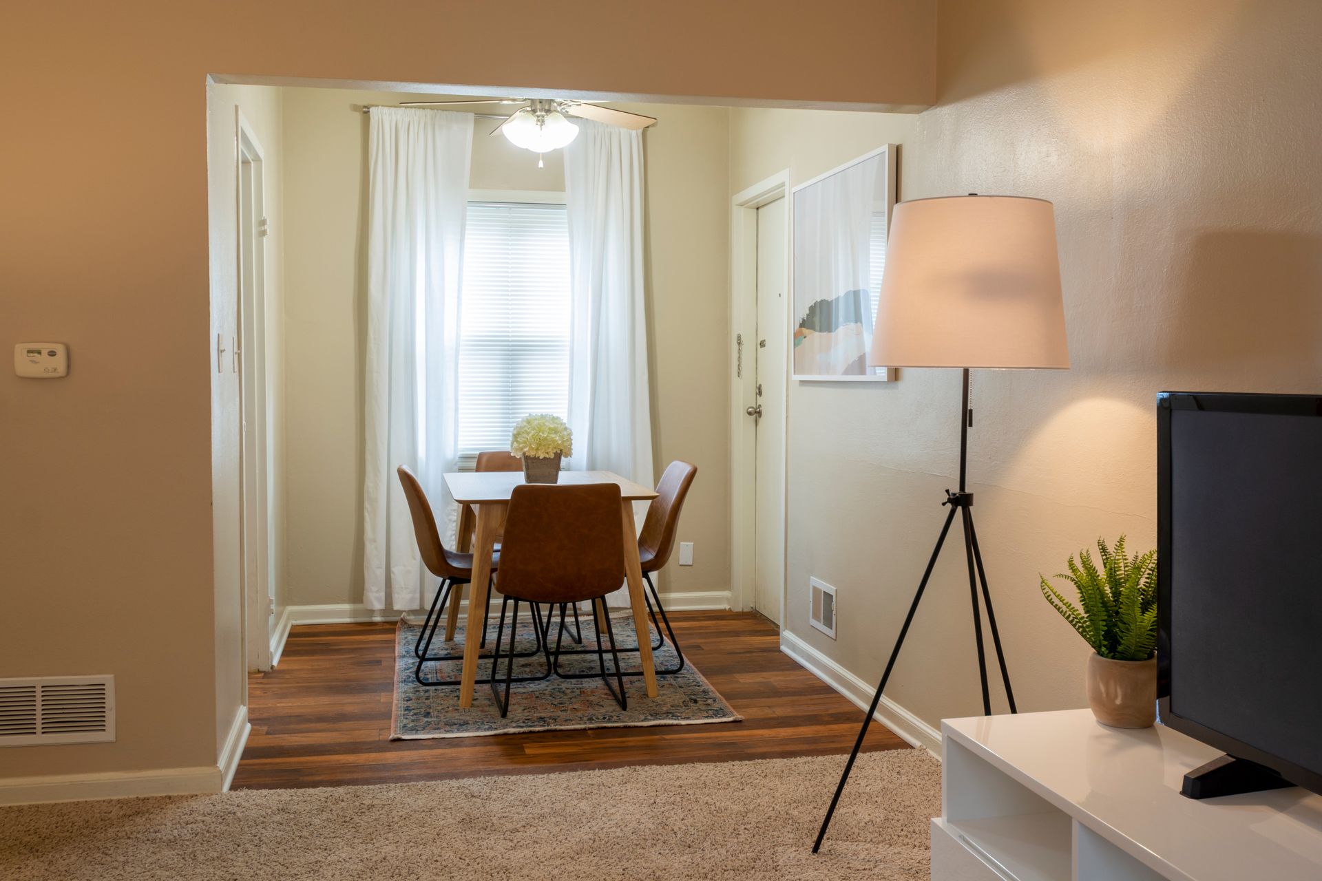 a dining room with a table and chairs and a lamp