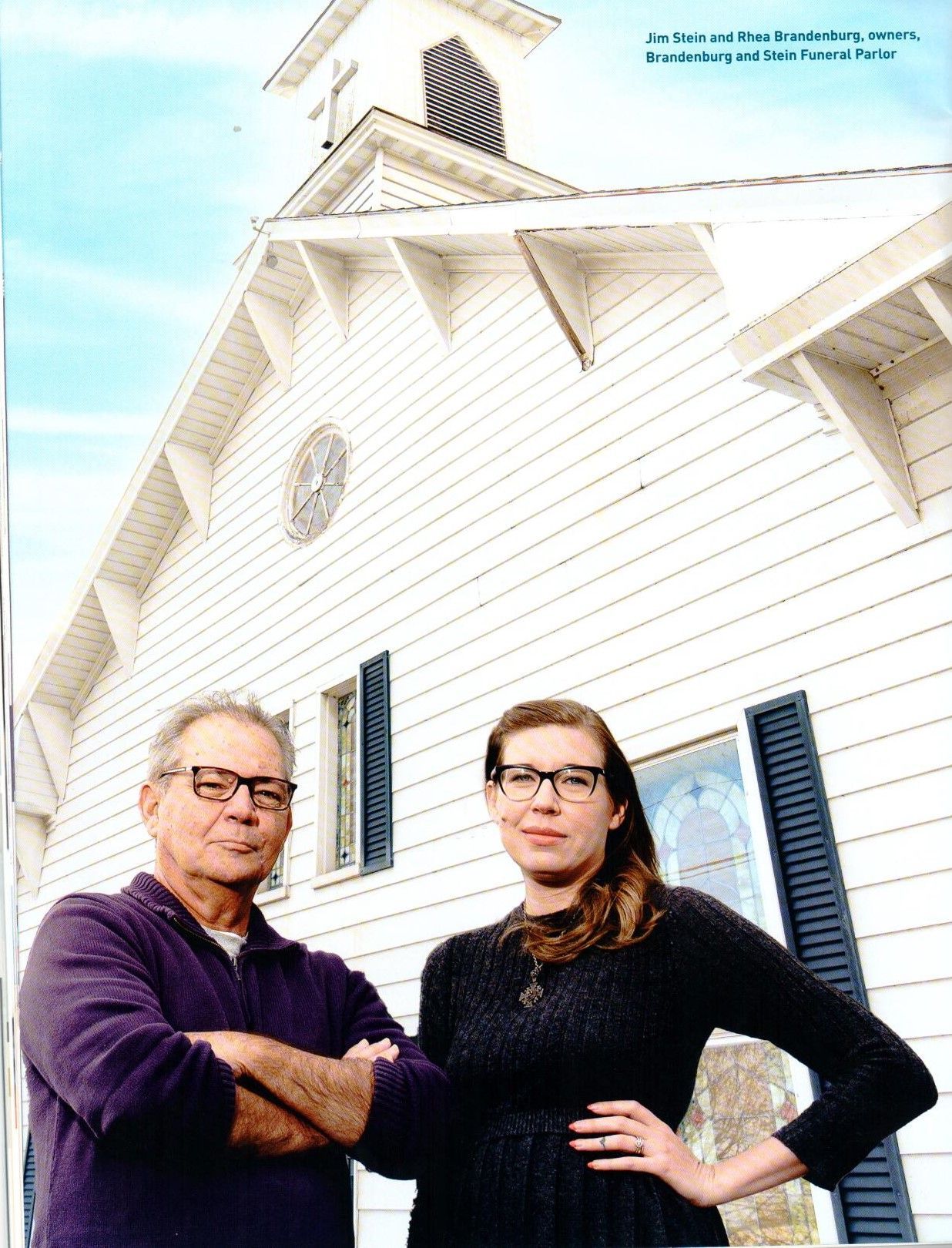 A man and a woman standing in front of a white building