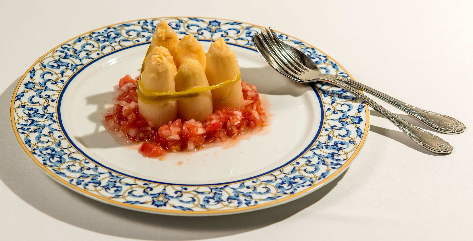 Un plato blanco cubierto con una ensalada de lechuga, tomate y rábanos.