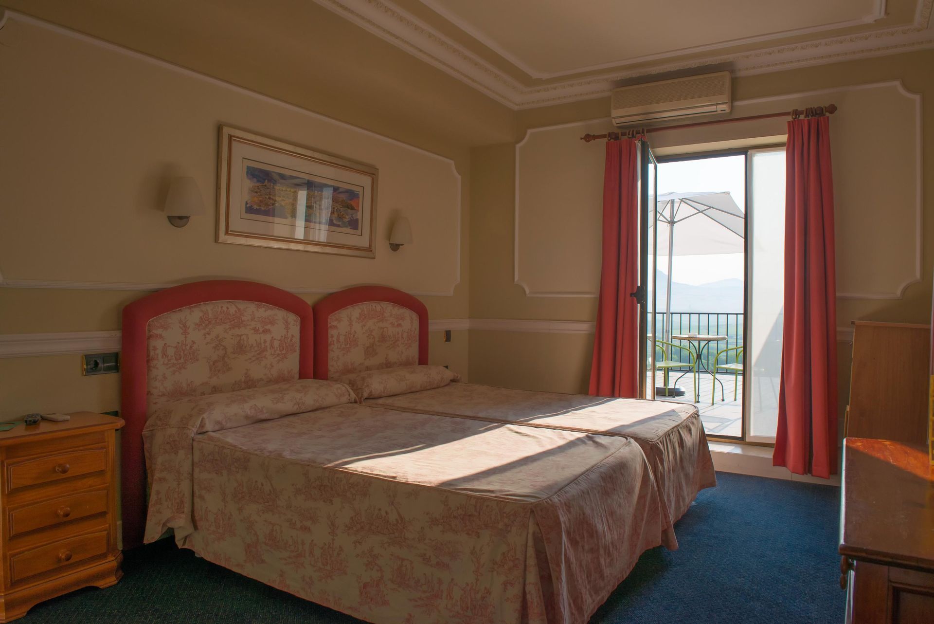 Una habitación de hotel con dos camas y balcón.