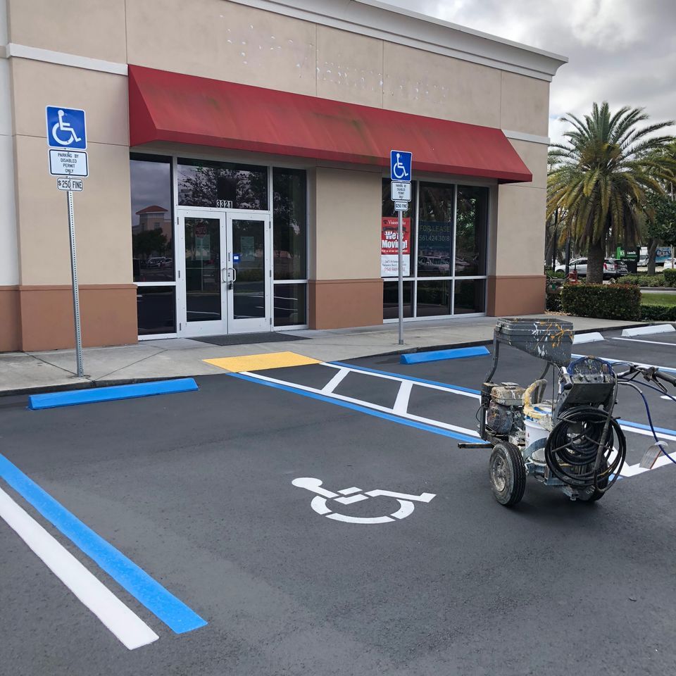 Exterior of a building with freshly painted blue and white lines indicating accessible parking spots.