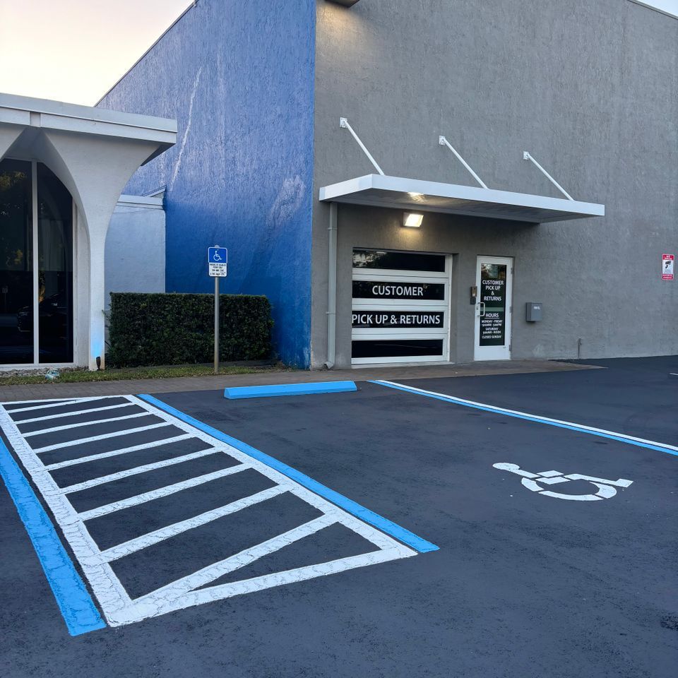 Exterior of a building with a drive-up pickup area and accessible parking. Blue and gray walls.