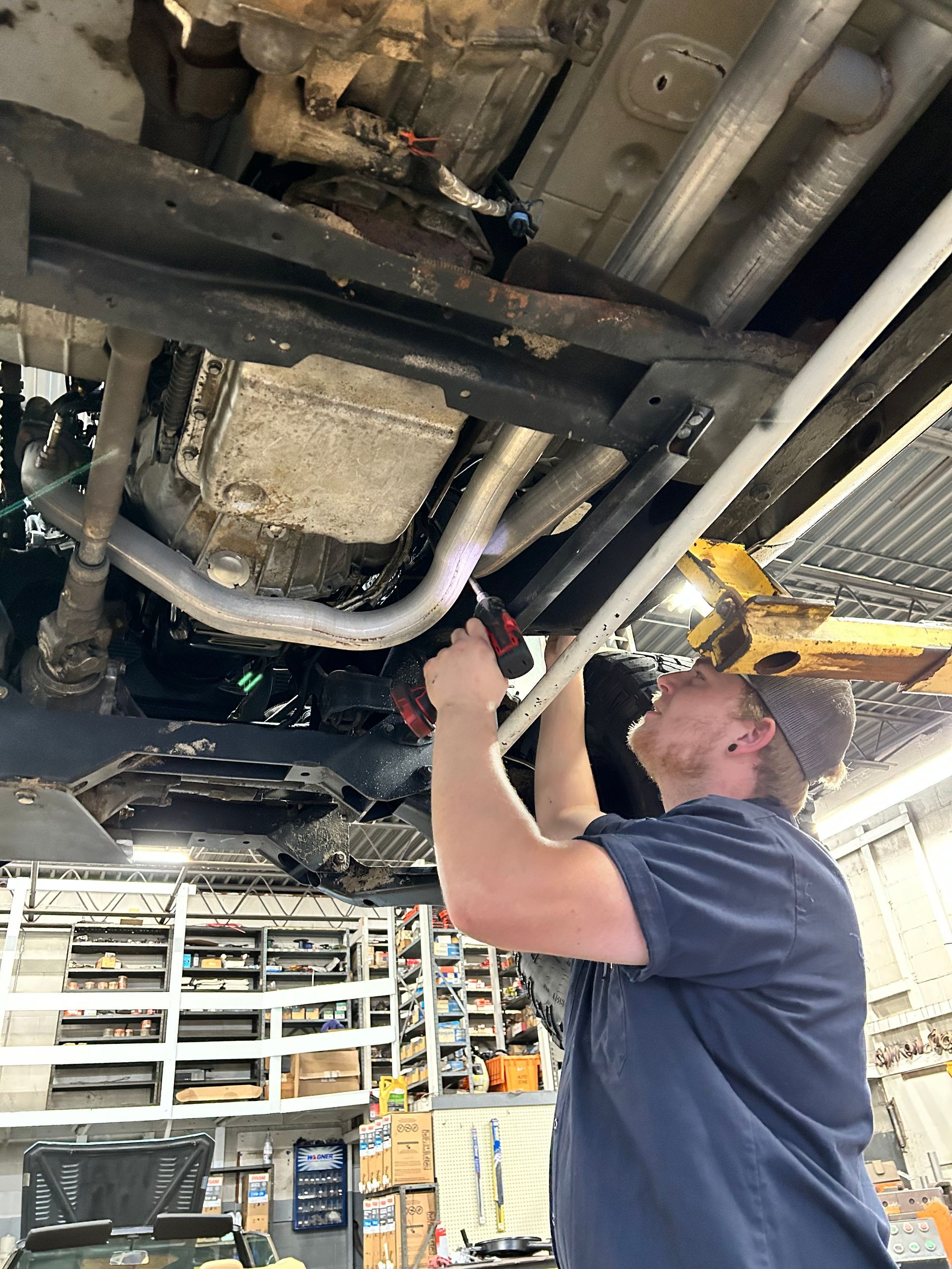 Mechanic Working on the Exhaust System of a Vehicle | Bussies Blue Star Automotive