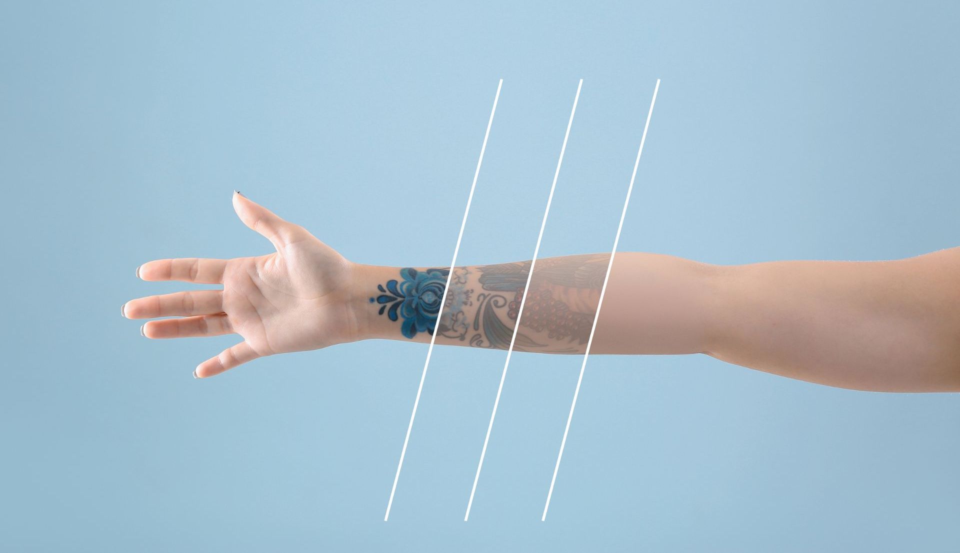 woman's arm with progressively fading tattoo isolated on blue background