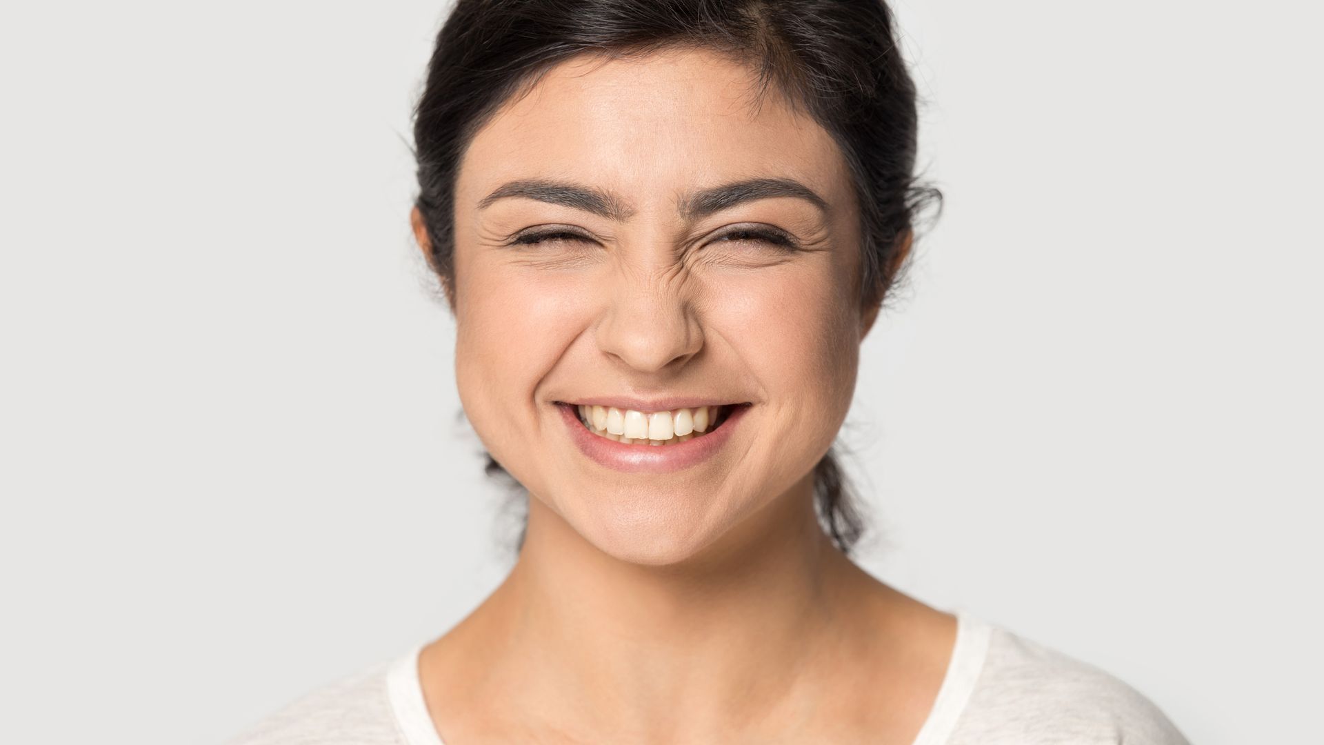 A Woman Is Smiling And Making A Funny Face With Her Eyes Closed – Terrigal, NSW - Anjule Beauty Therapy