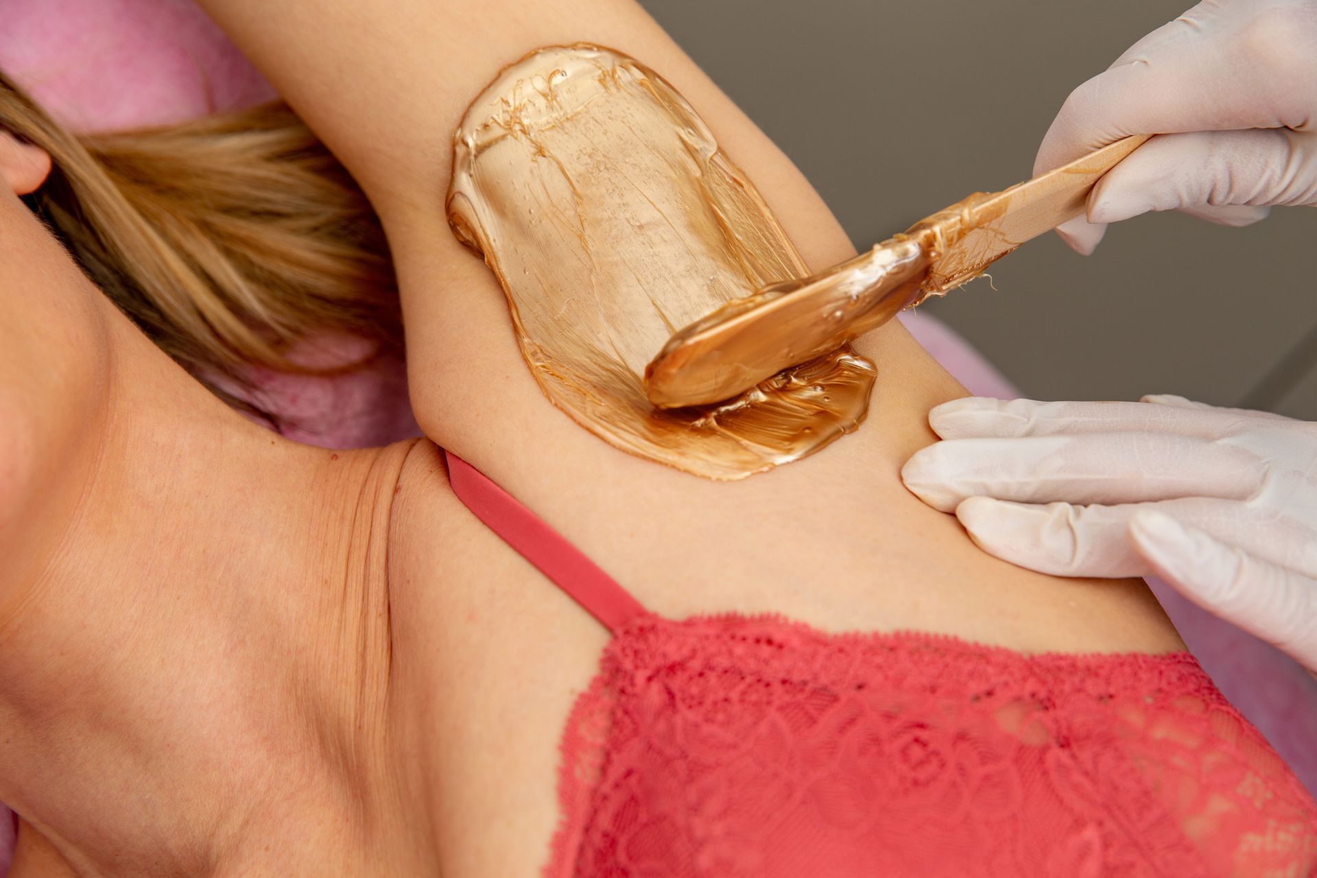 A Woman In A Red Bra Is Getting Her Armpit Waxed – Terrigal, NSW - Anjule Beauty Therapy