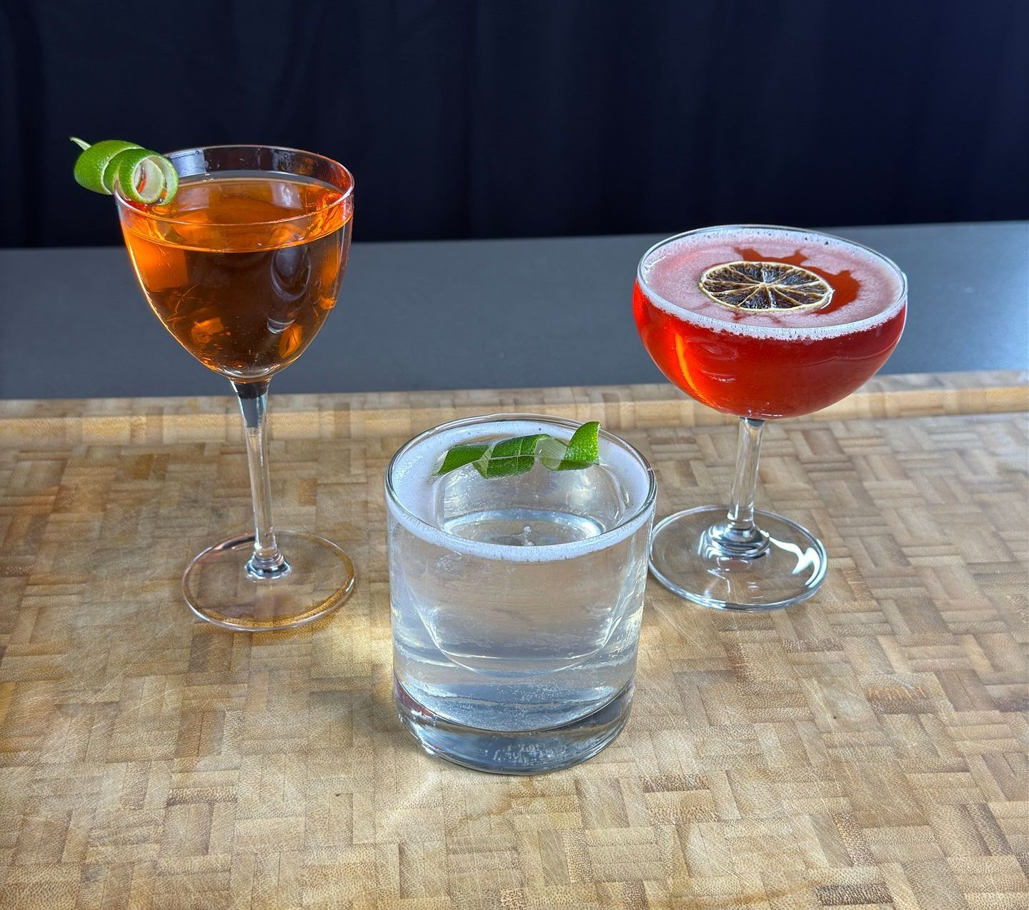 Three different types of drinks are sitting on a wooden table.