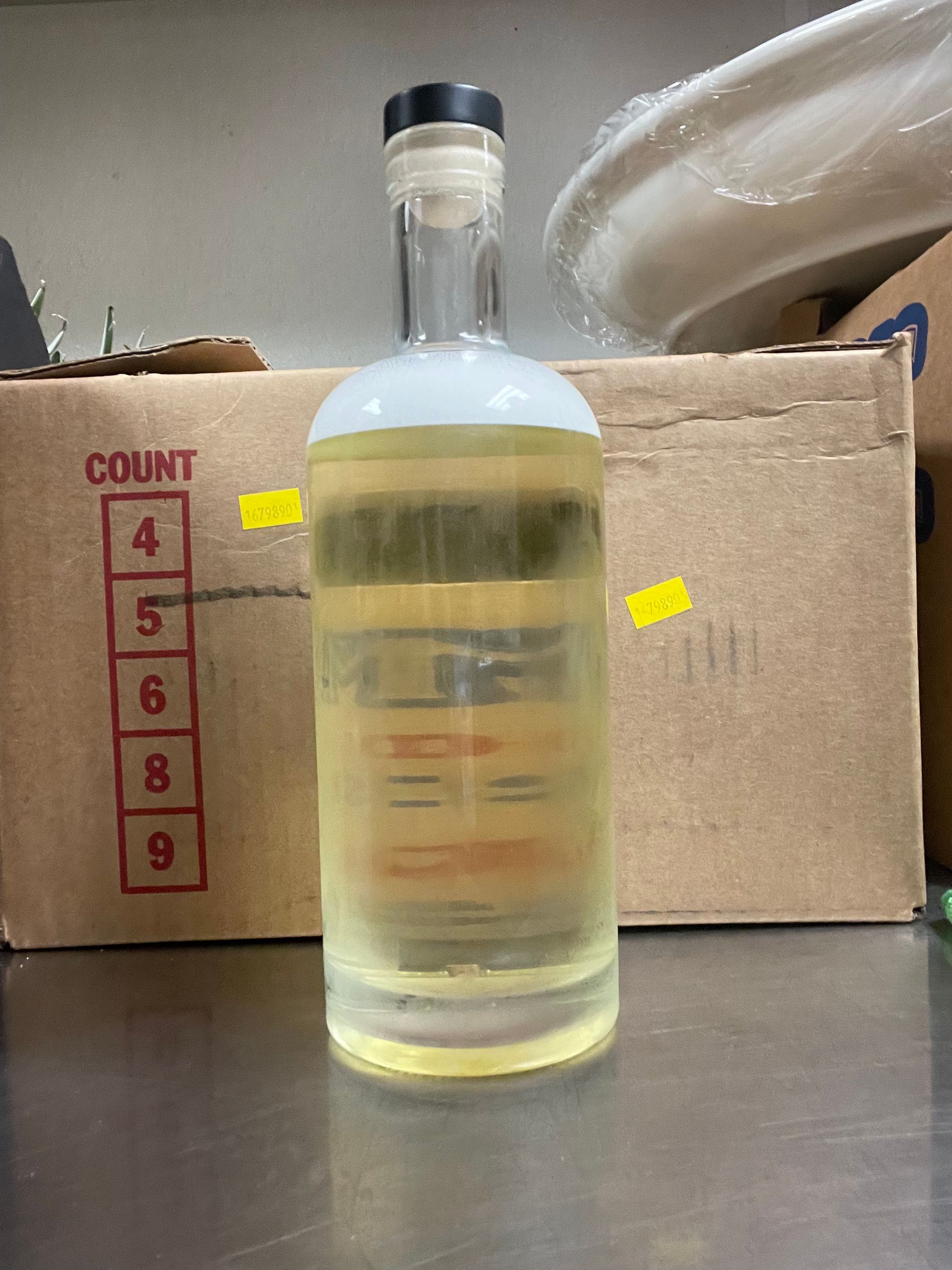 Three bottles of different colored liquid are on a counter