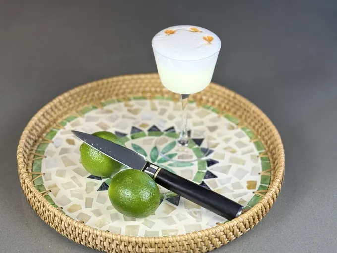 A glass of liquid with a slice of lime and mint on top.