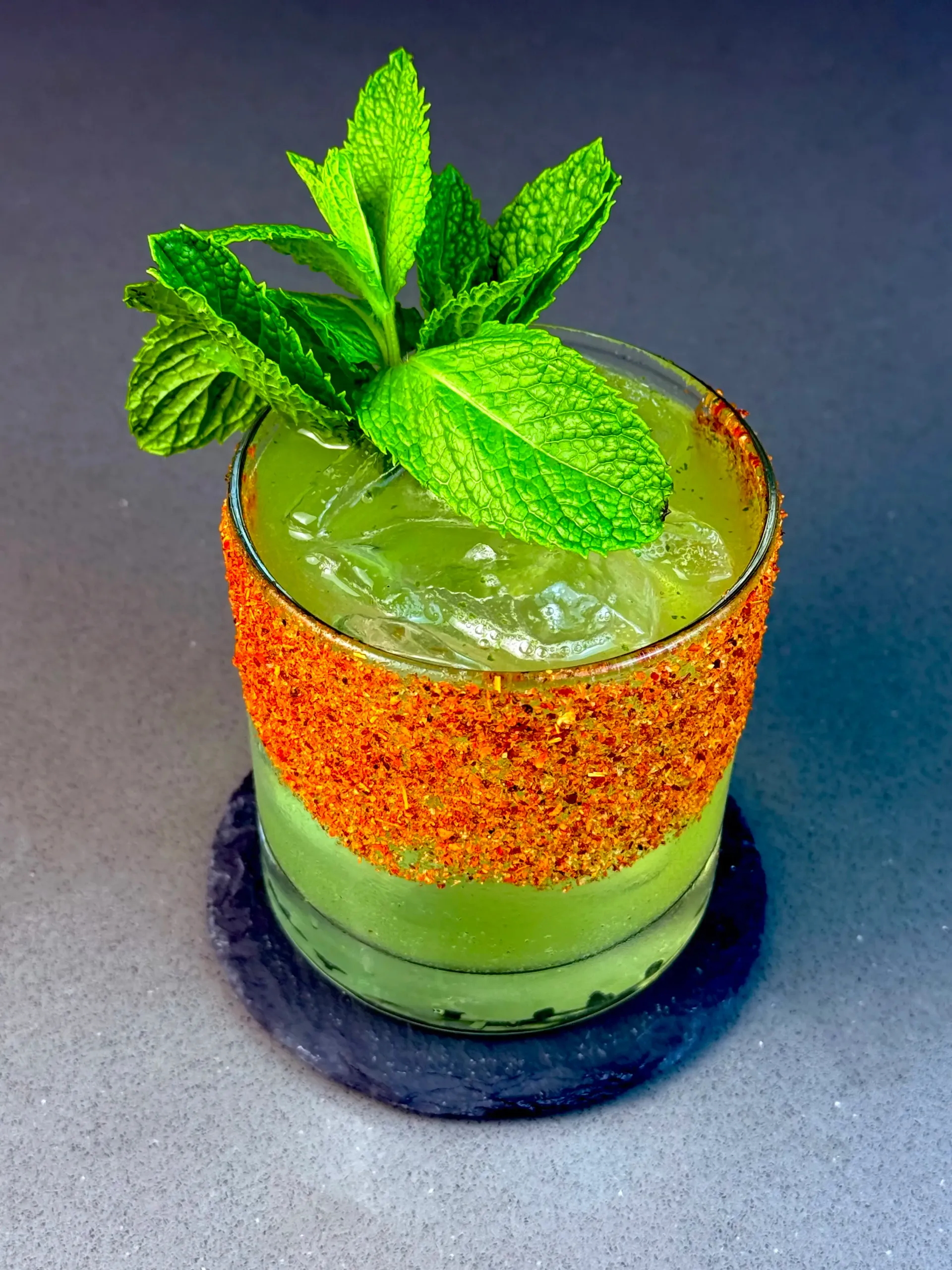 Tamarindo Verde cocktail with tequila, tamarind, mint, and Tajin rim