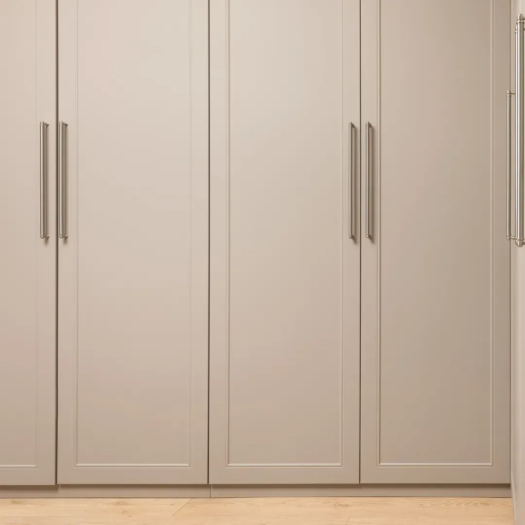 A kitchen with white cabinets and a refrigerator.