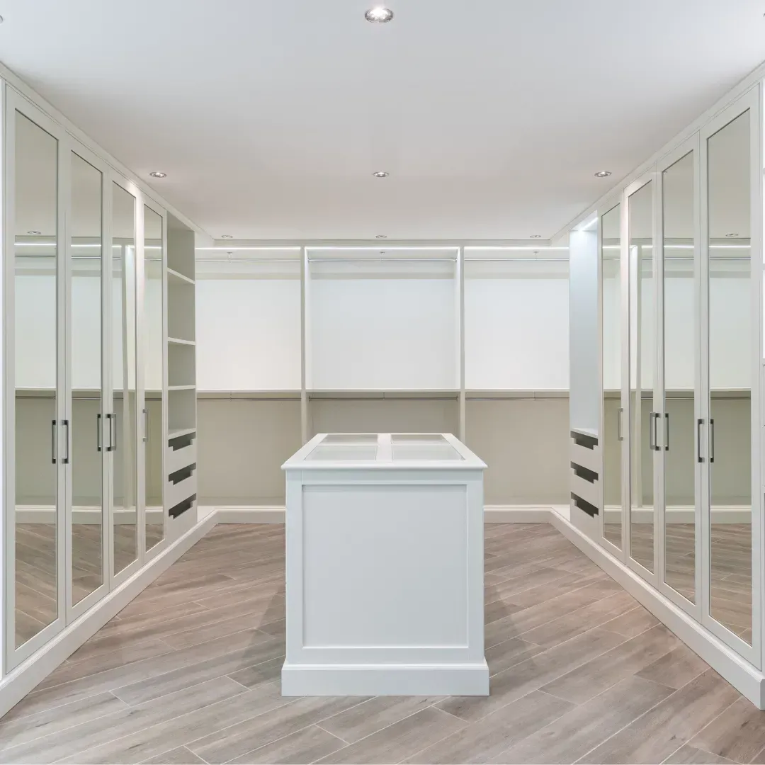 A walk in closet with a large island in the middle