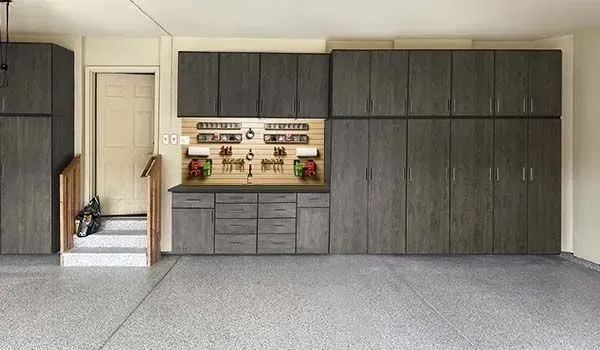 A garage with lots of cabinets and a workbench.