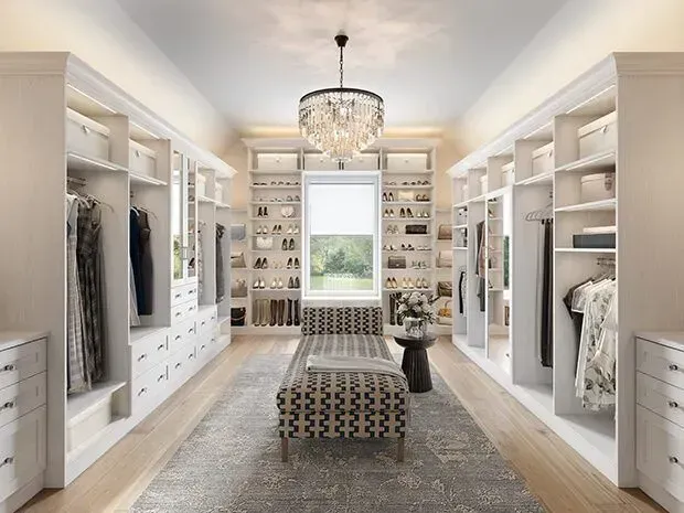 A large walk in closet with a bench and a chandelier