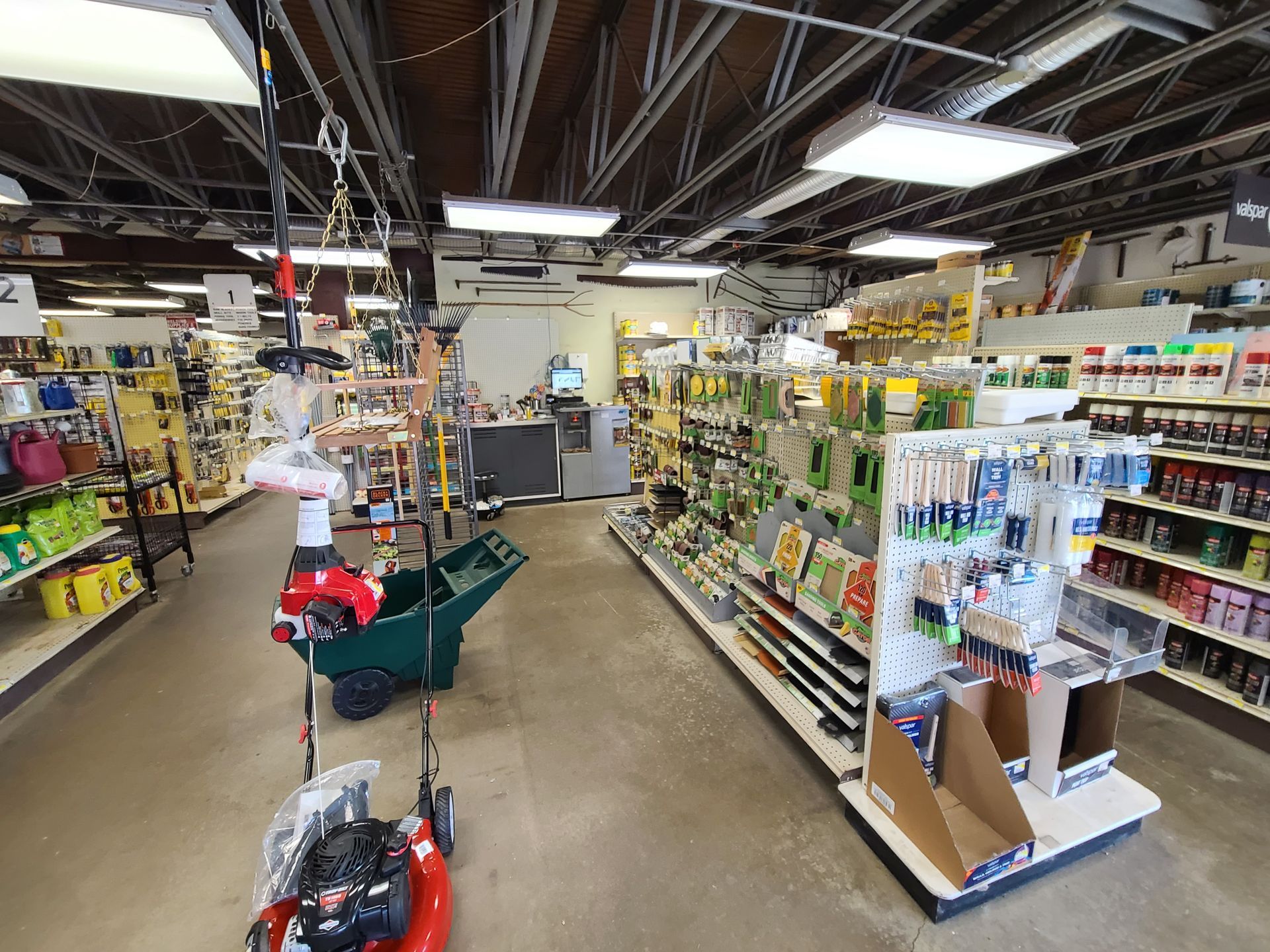 The inside of a hardware store with a lawn mower in the middle