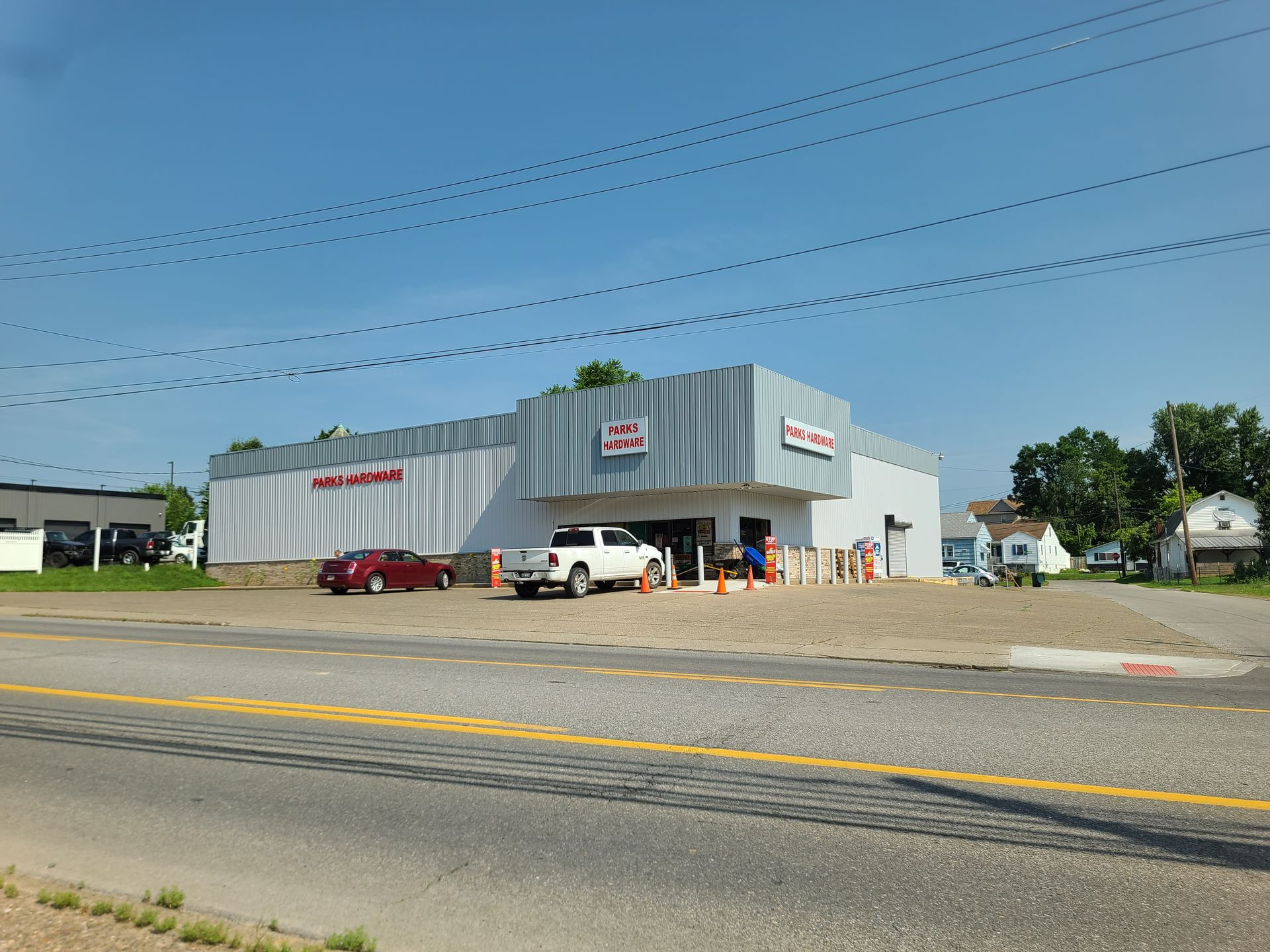A white truck is parked in front of a large building.