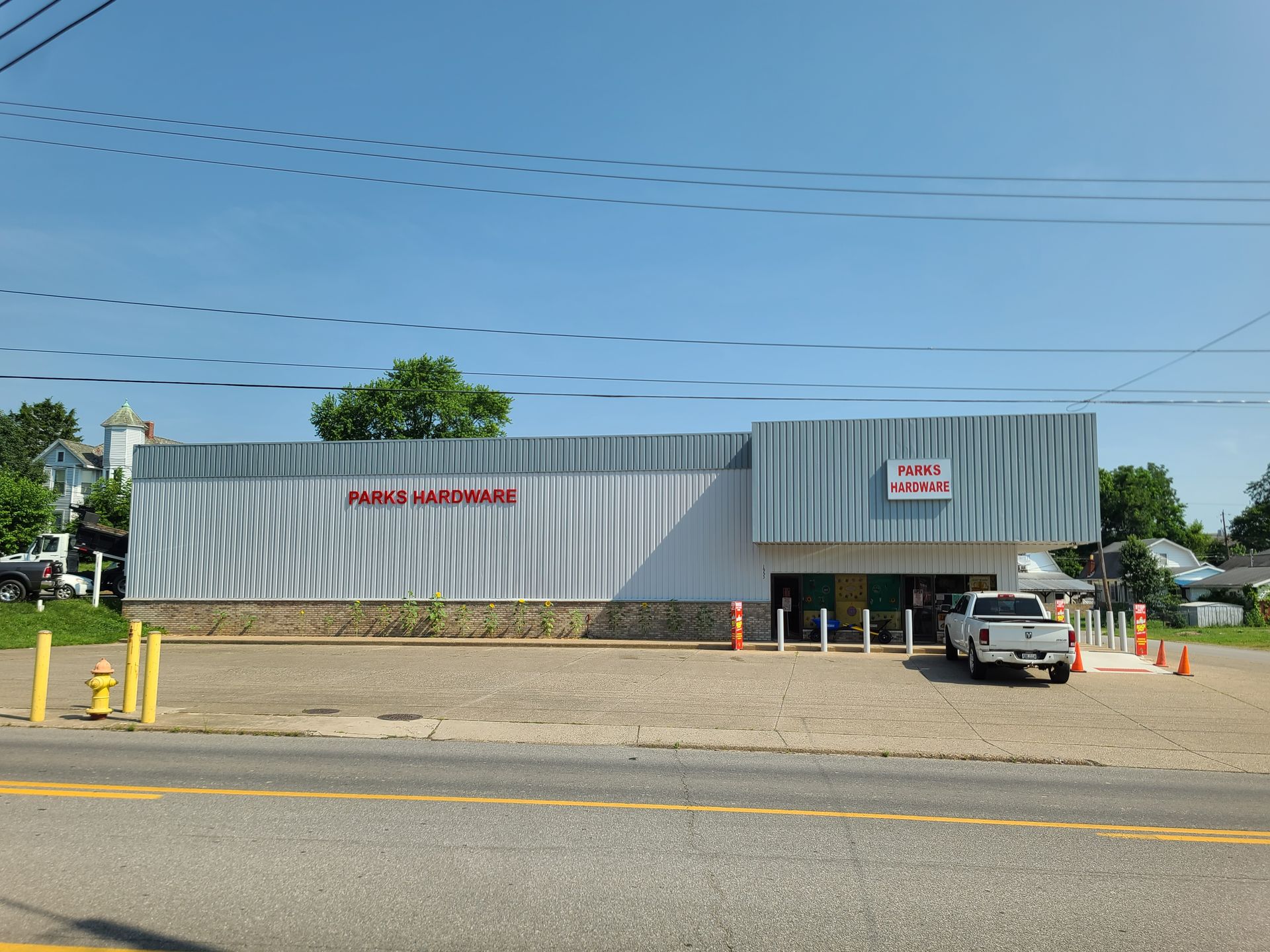 A white truck is parked in front of a large building.