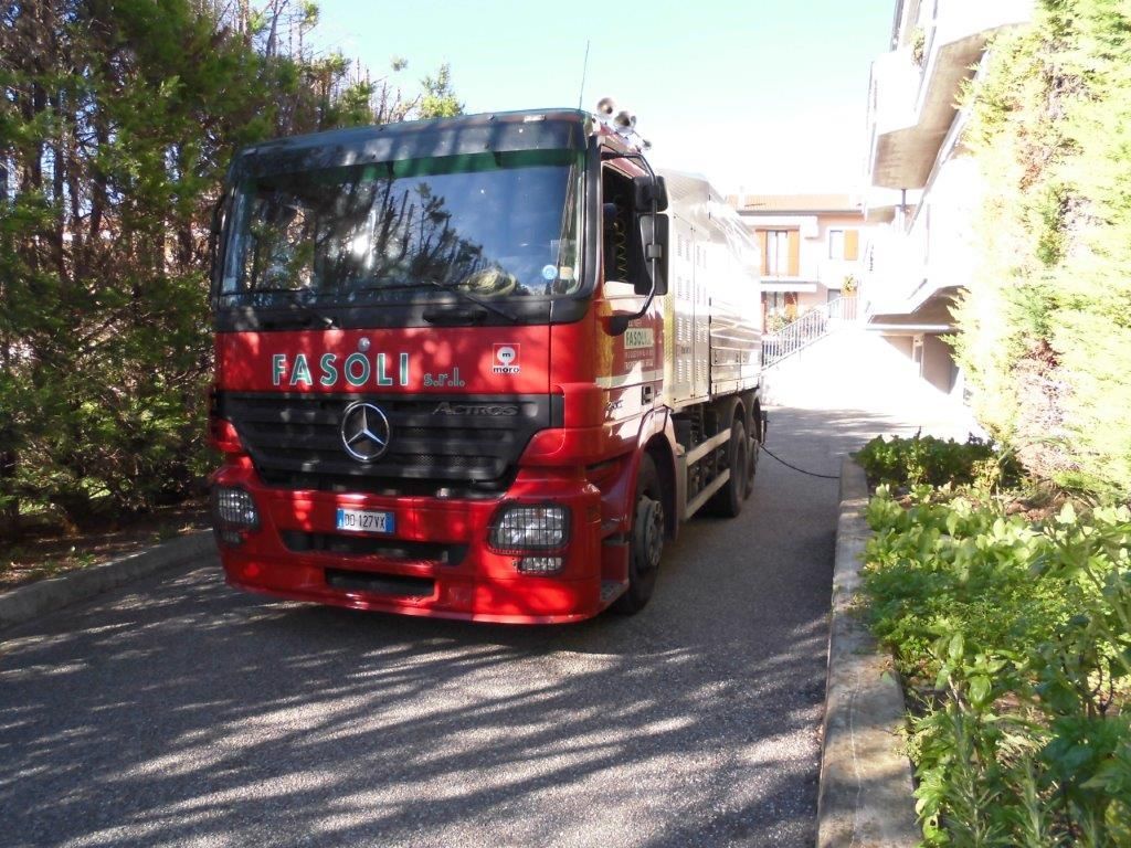 Un camion Mercedes rosso è parcheggiato sul ciglio della strada