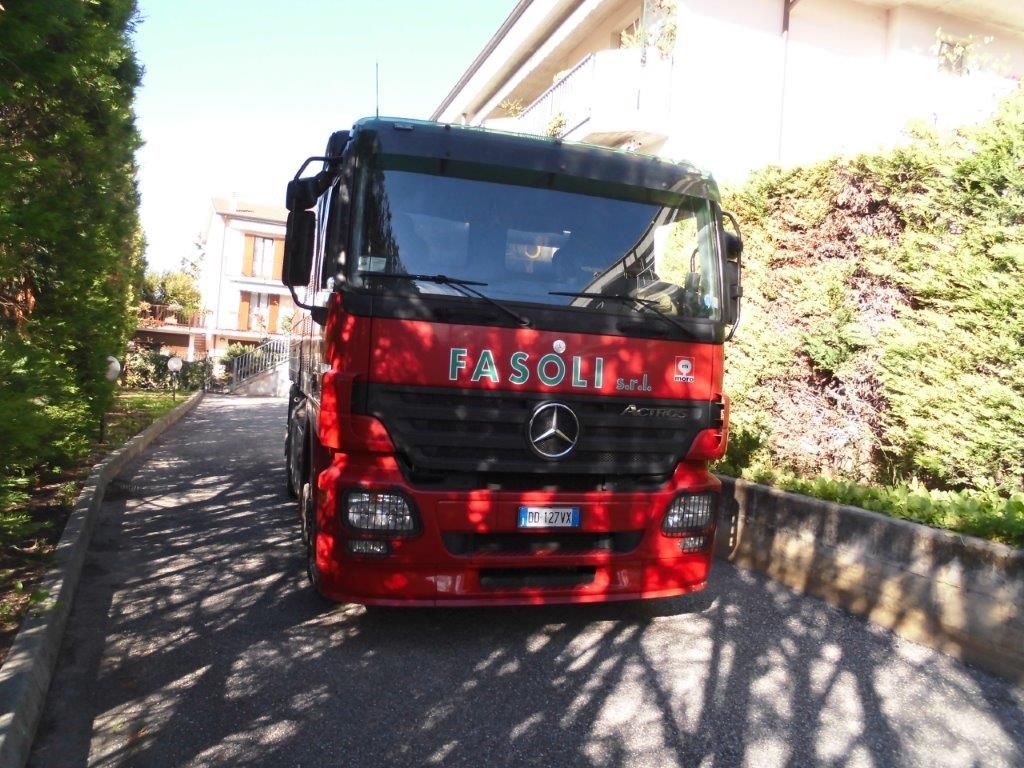 Un camion Mercedes rosso è parcheggiato in un vialetto