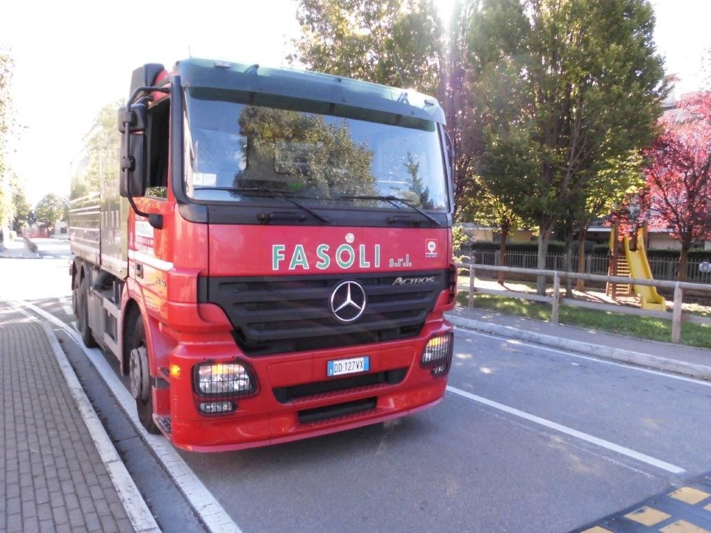 Un camion Mercedes rosso è parcheggiato sul ciglio della strada