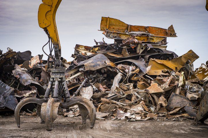 Large tracked excavator working a steel pile at a metal recycle