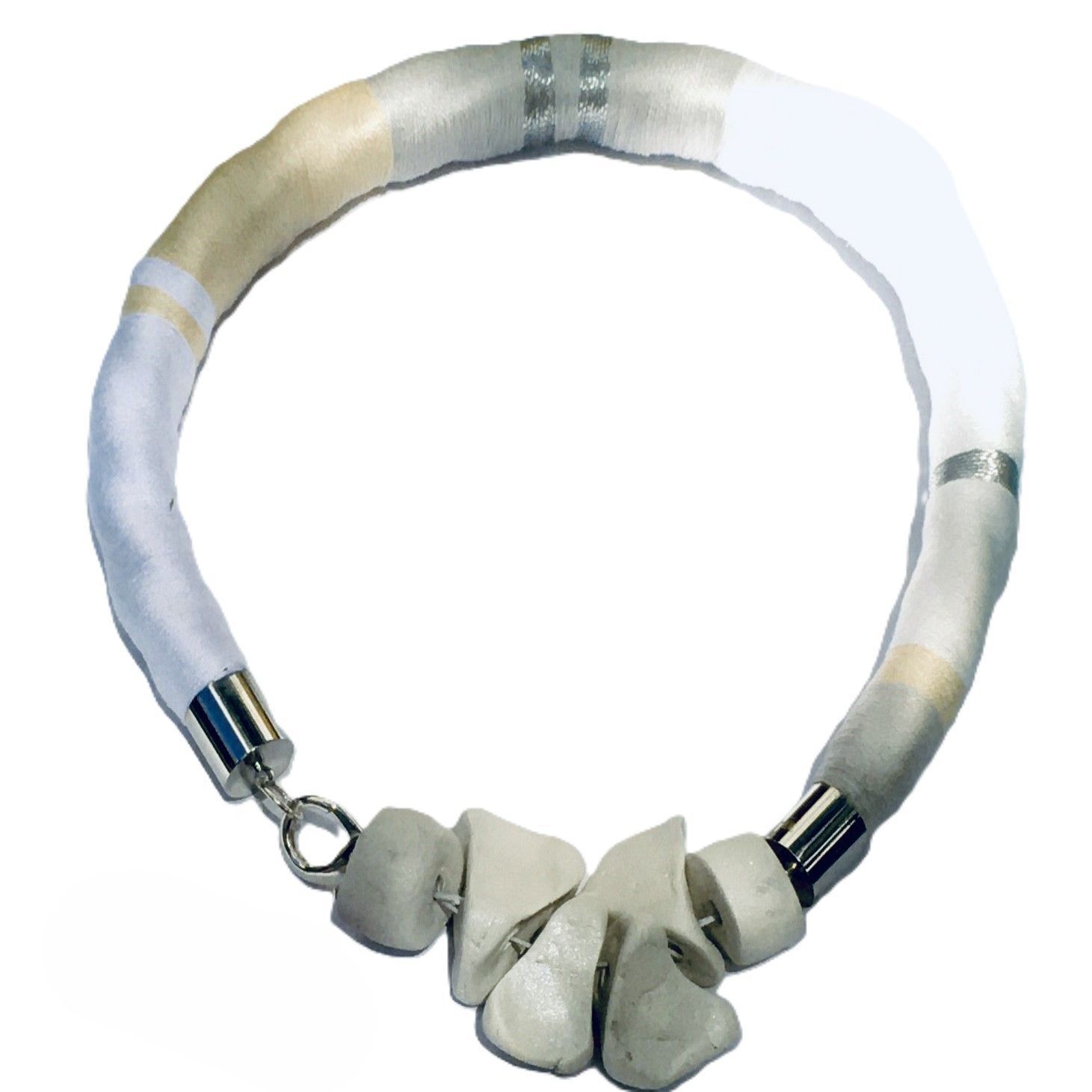 Un collar blanco con un cierre de plata sobre un fondo blanco.