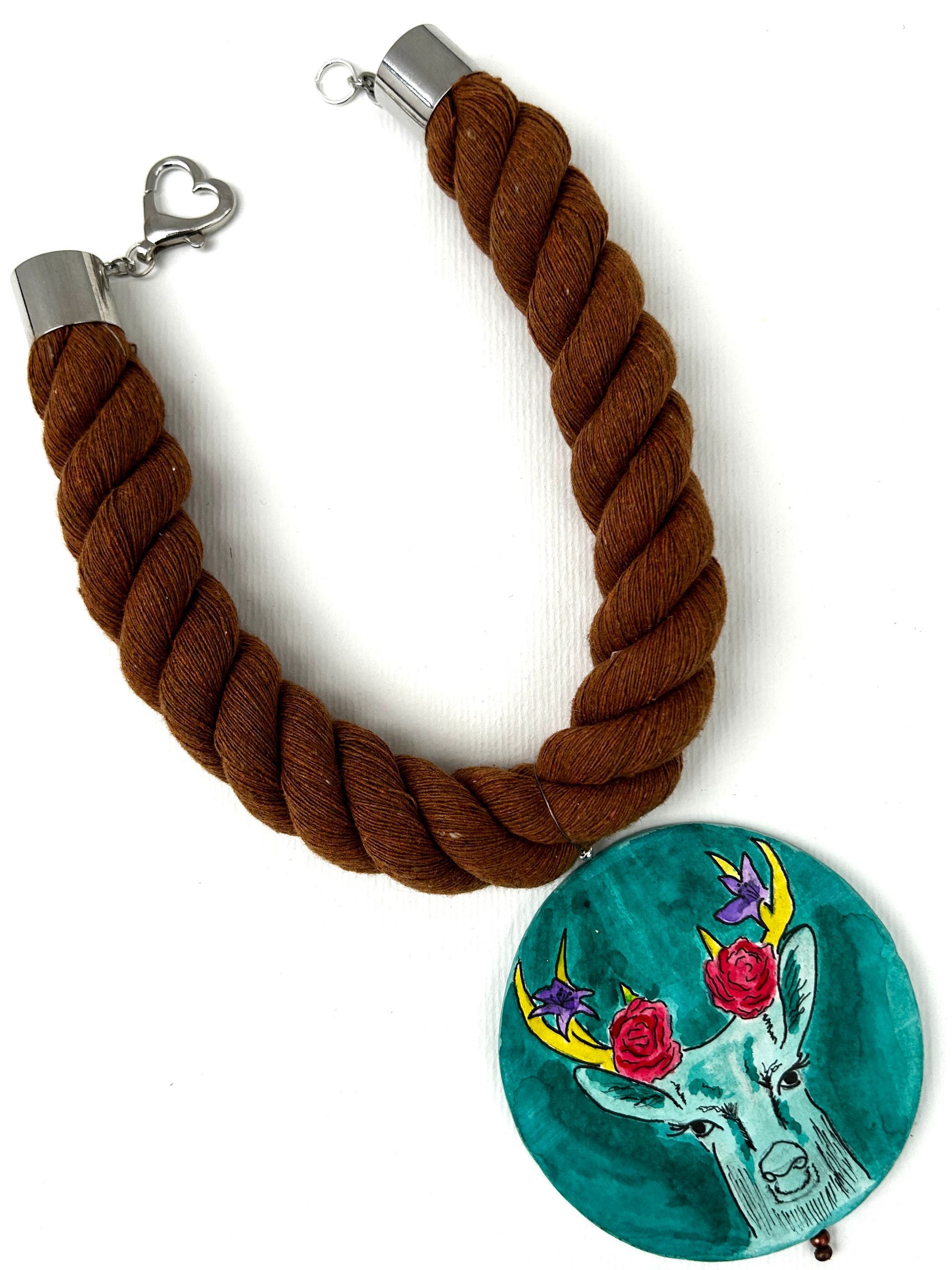 Un collar de cuerda marrón con un colgante de ciervo.