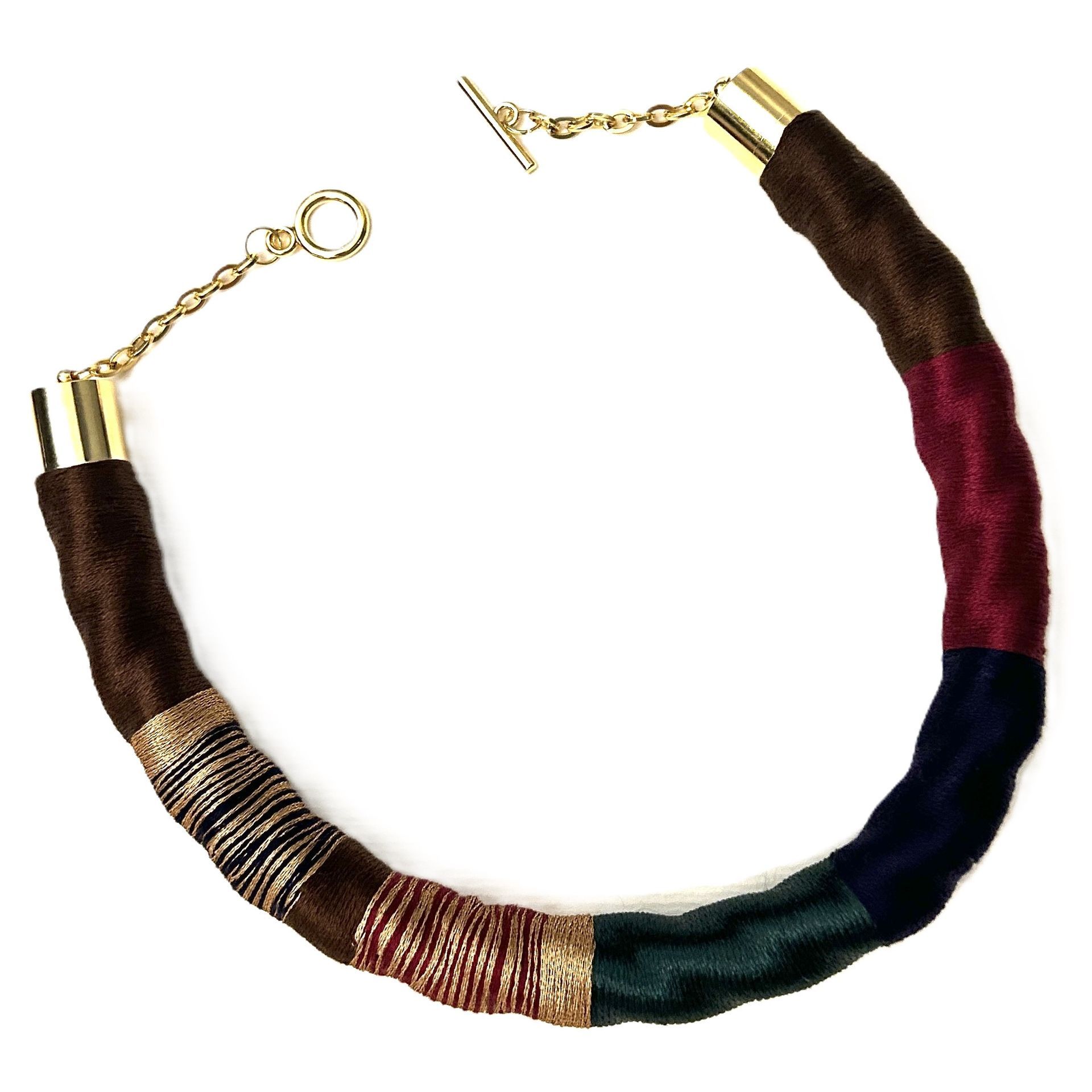 Un collar colorido con una cadena de oro sobre un fondo blanco.