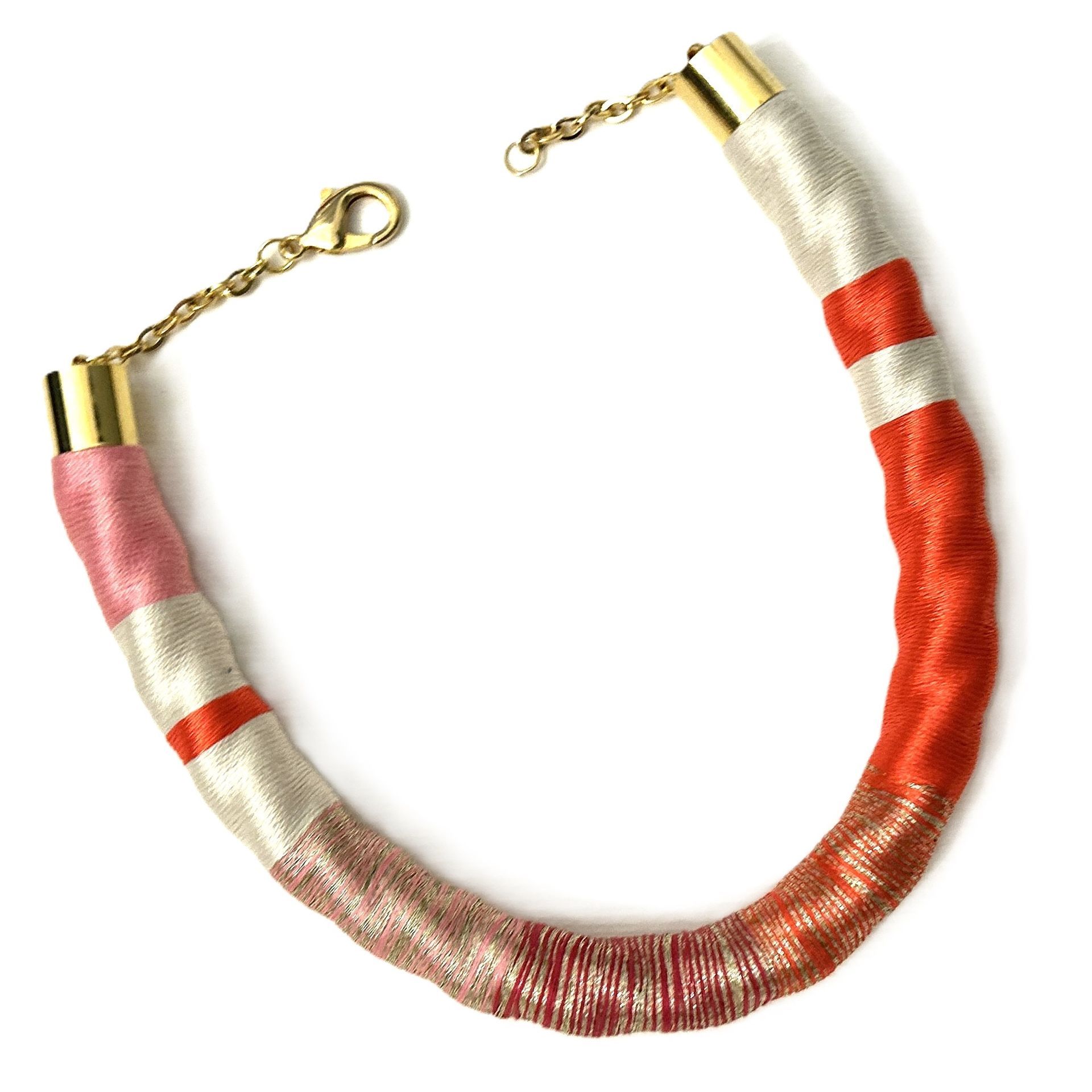 Un collar rojo y blanco con un cierre dorado.
