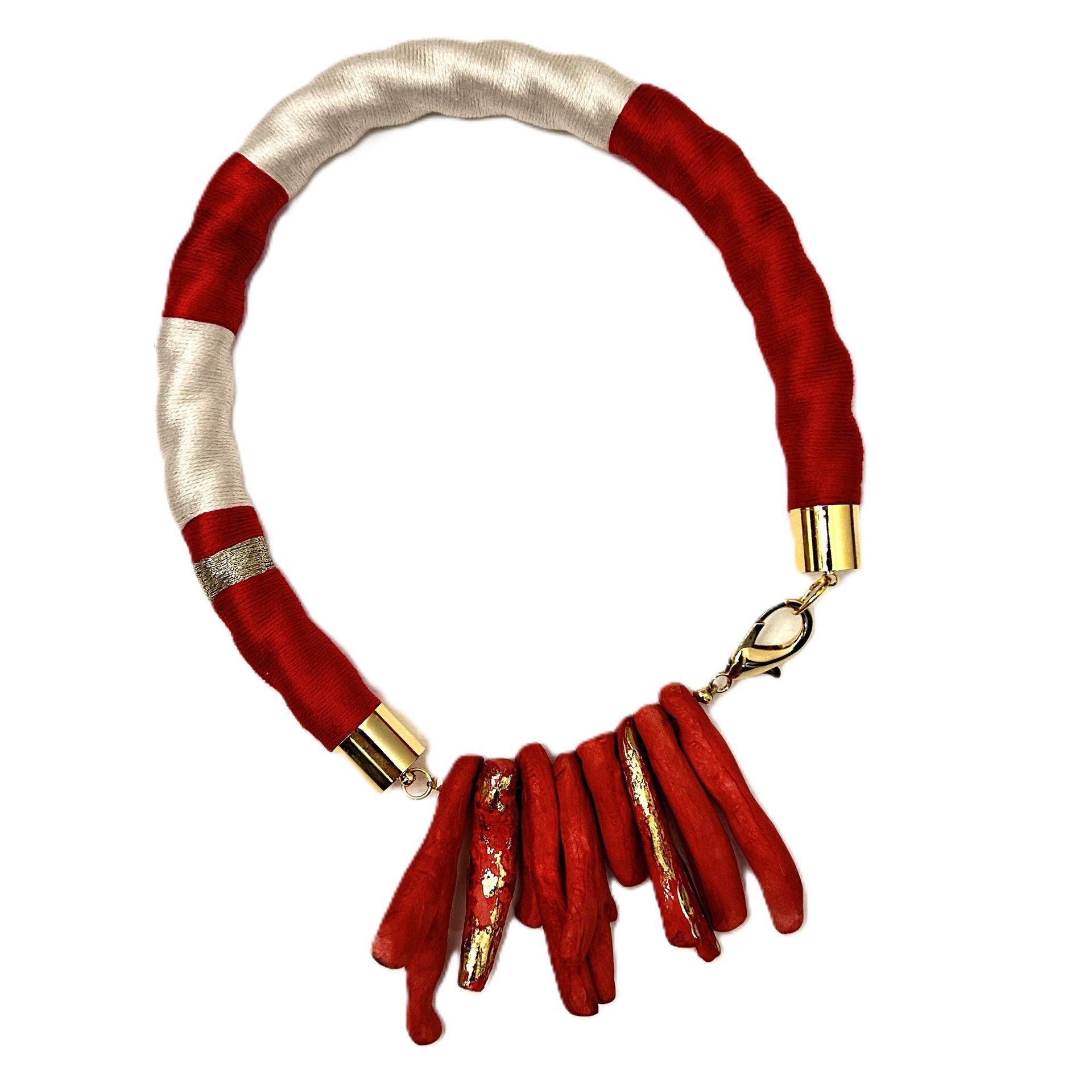 Un collar rojo y blanco con un cierre dorado.
