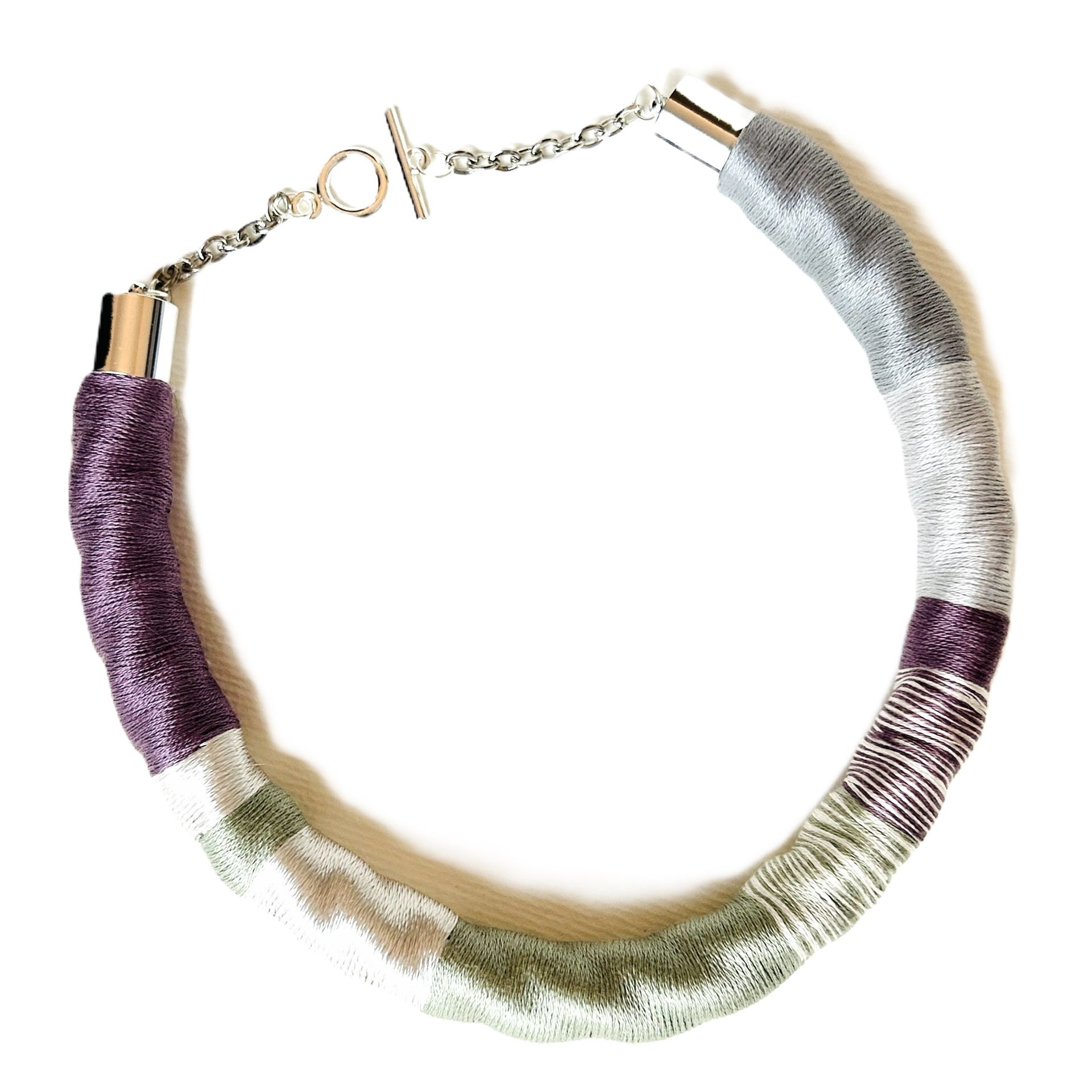 Un collar morado y verde con una cadena de plata.